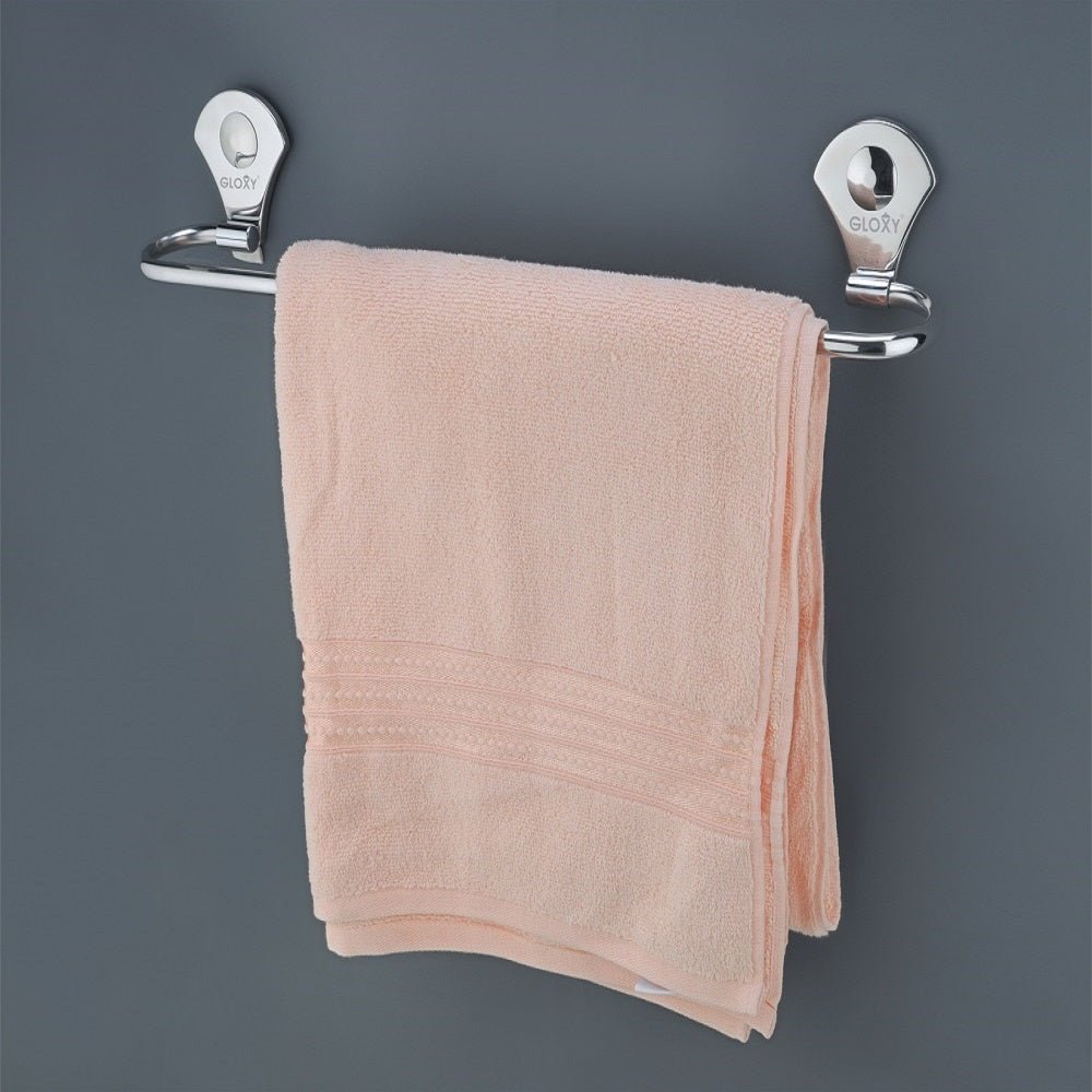 A stainless steel towel rod with a towel hanging on it, installed on a wall.