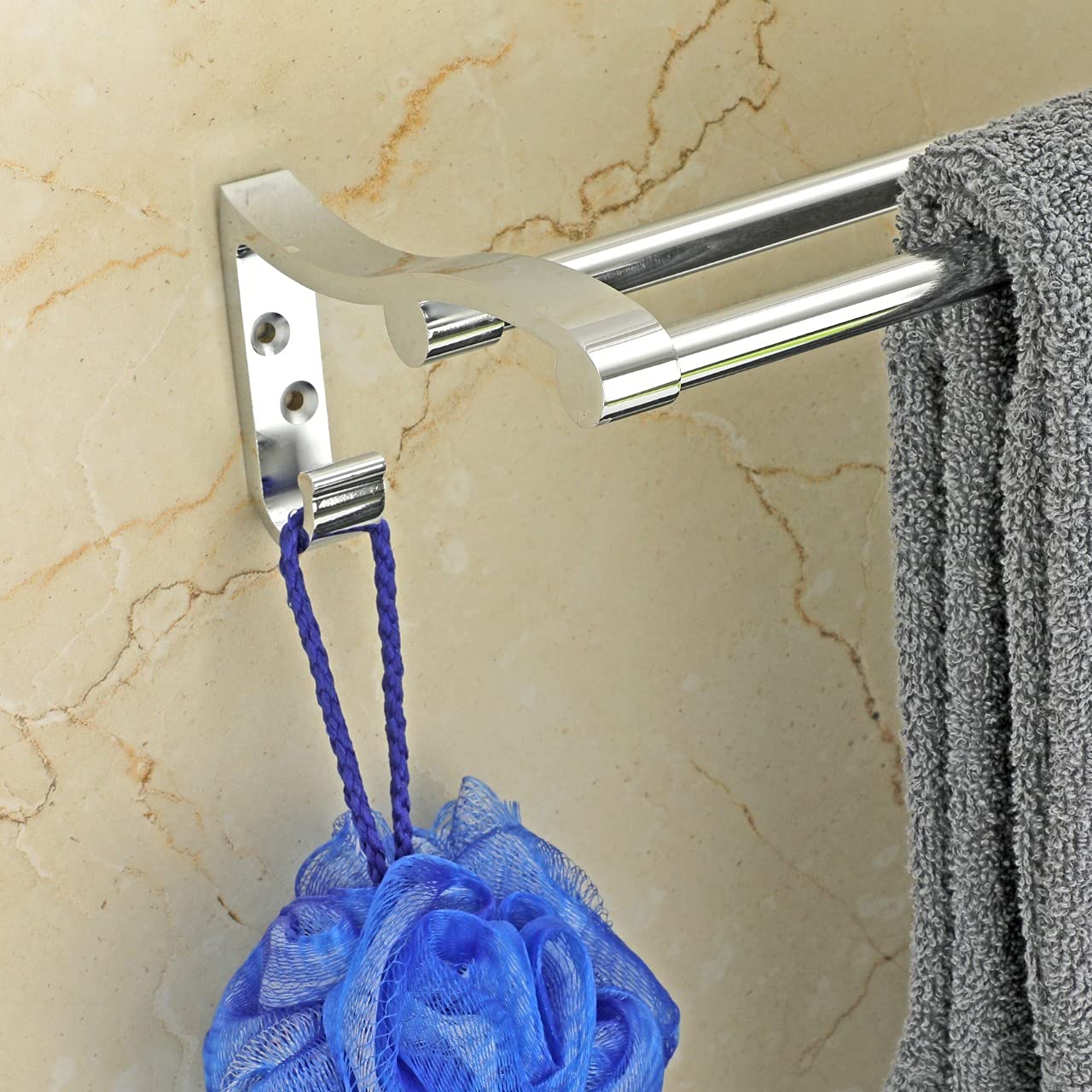 Metal towel rack with blue loofah and gray towel on marble background