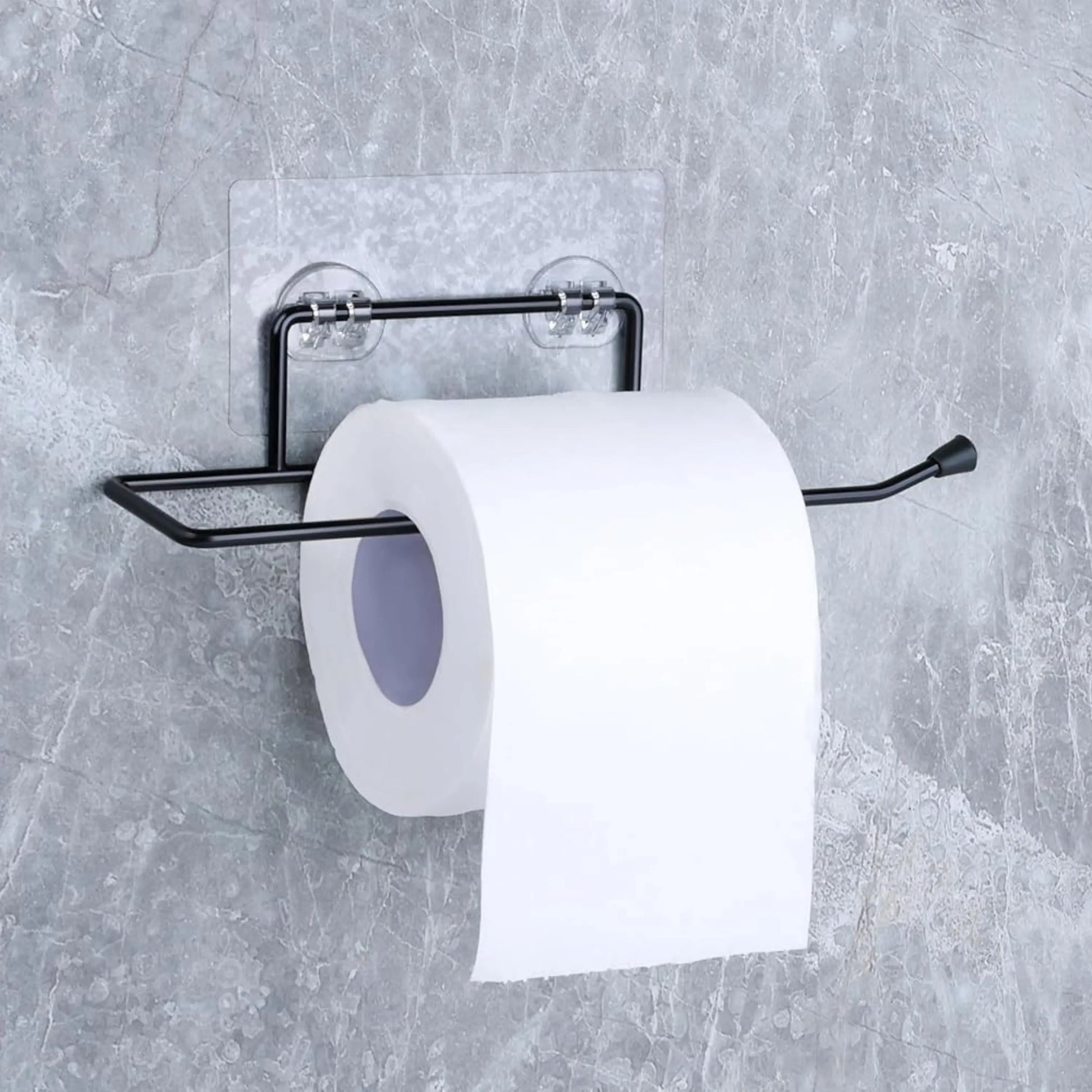 Black toilet paper holder with a roll of toilet paper on a gray wall.