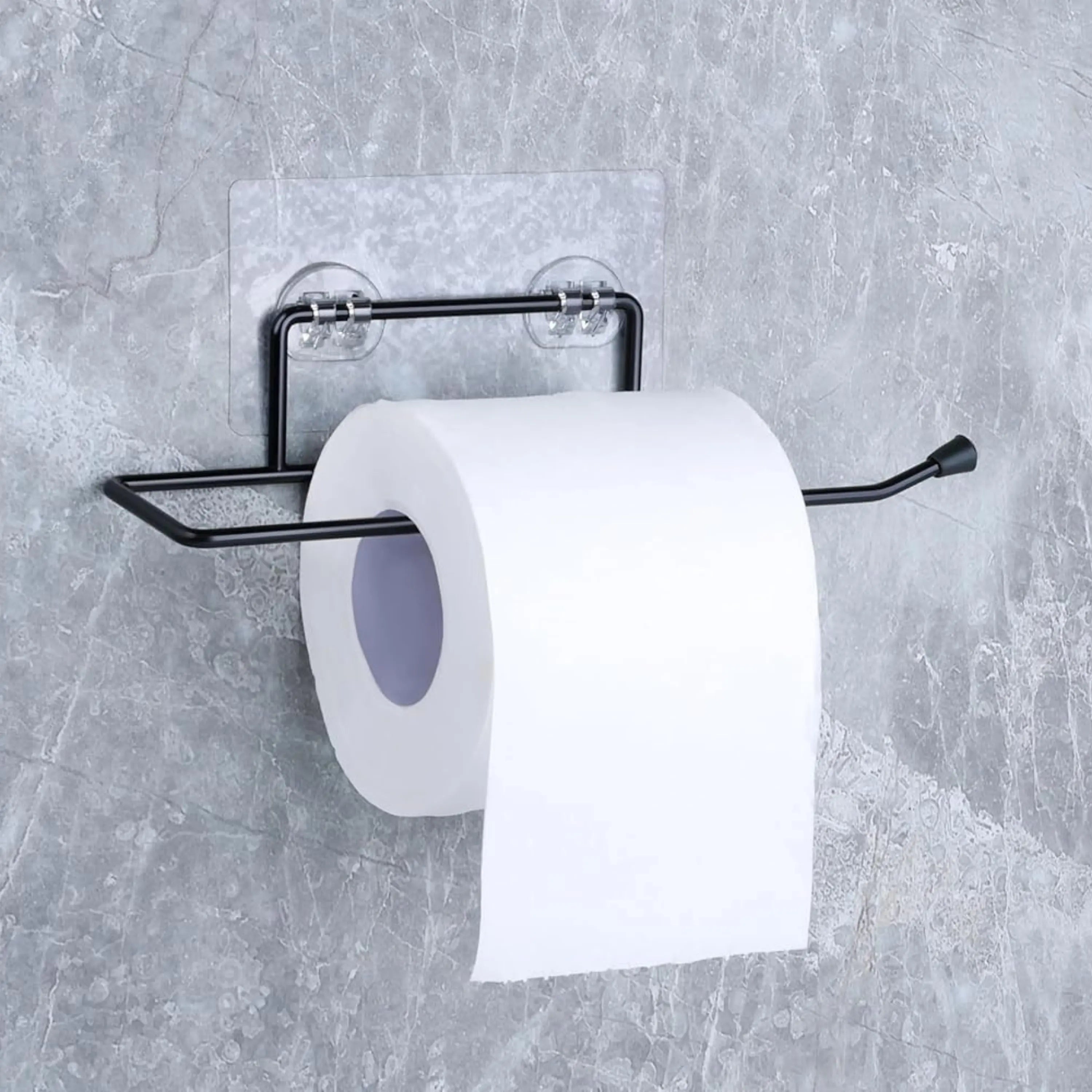 Black toilet paper holder with a roll of toilet paper on a gray wall.