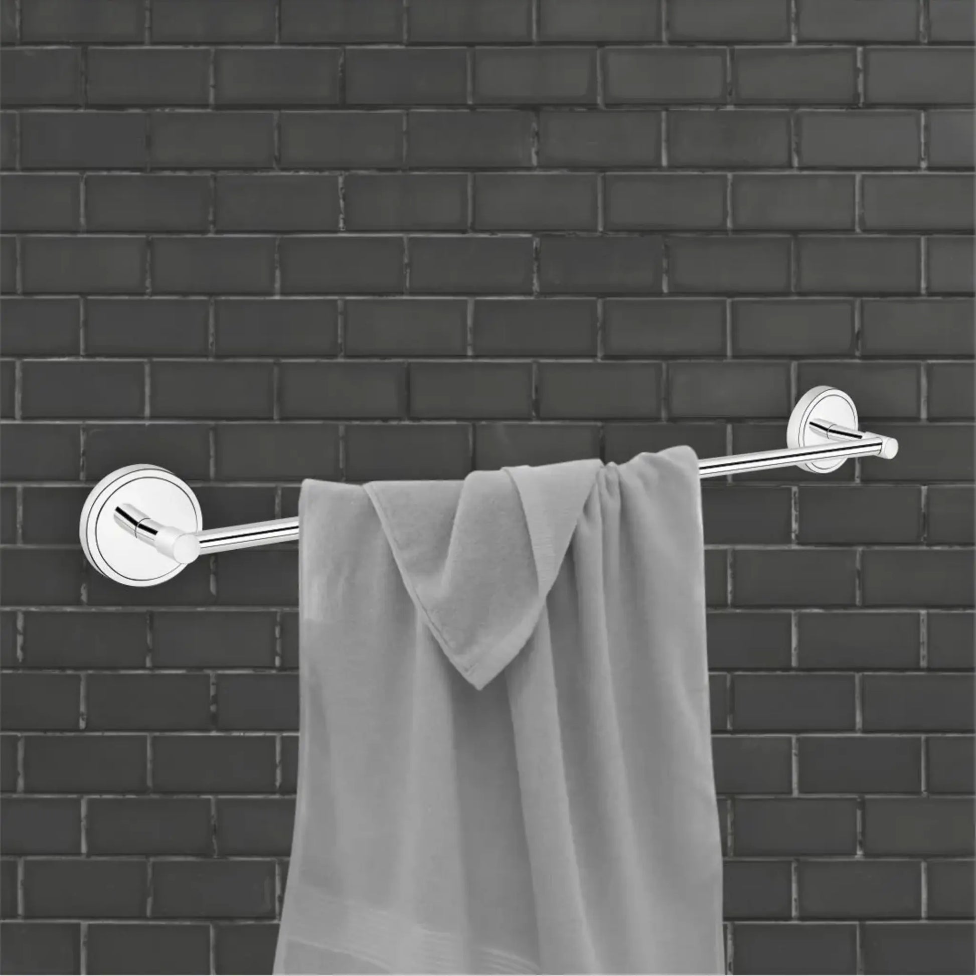 Gray towel hanging on a silver towel rack against a black brick wall.
