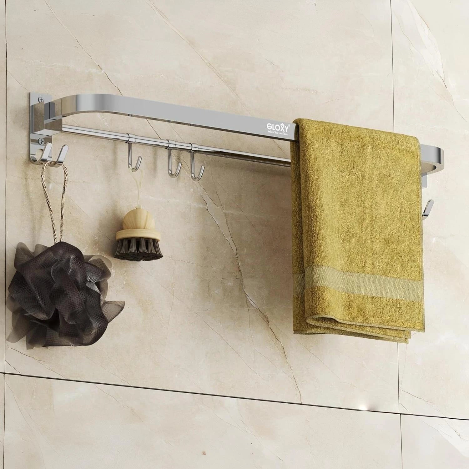 Bathroom towel rack with a yellow towel, black scrubber, and gray loofah against a tiled wall.