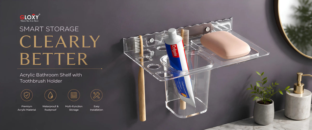 Clear acrylic bathroom shelf with integrated toothbrush holder, cup, and soap dish mounted on a dark gray bathroom wall. The shelf holds a toothbrush, tube of toothpaste, and a bar of soap.