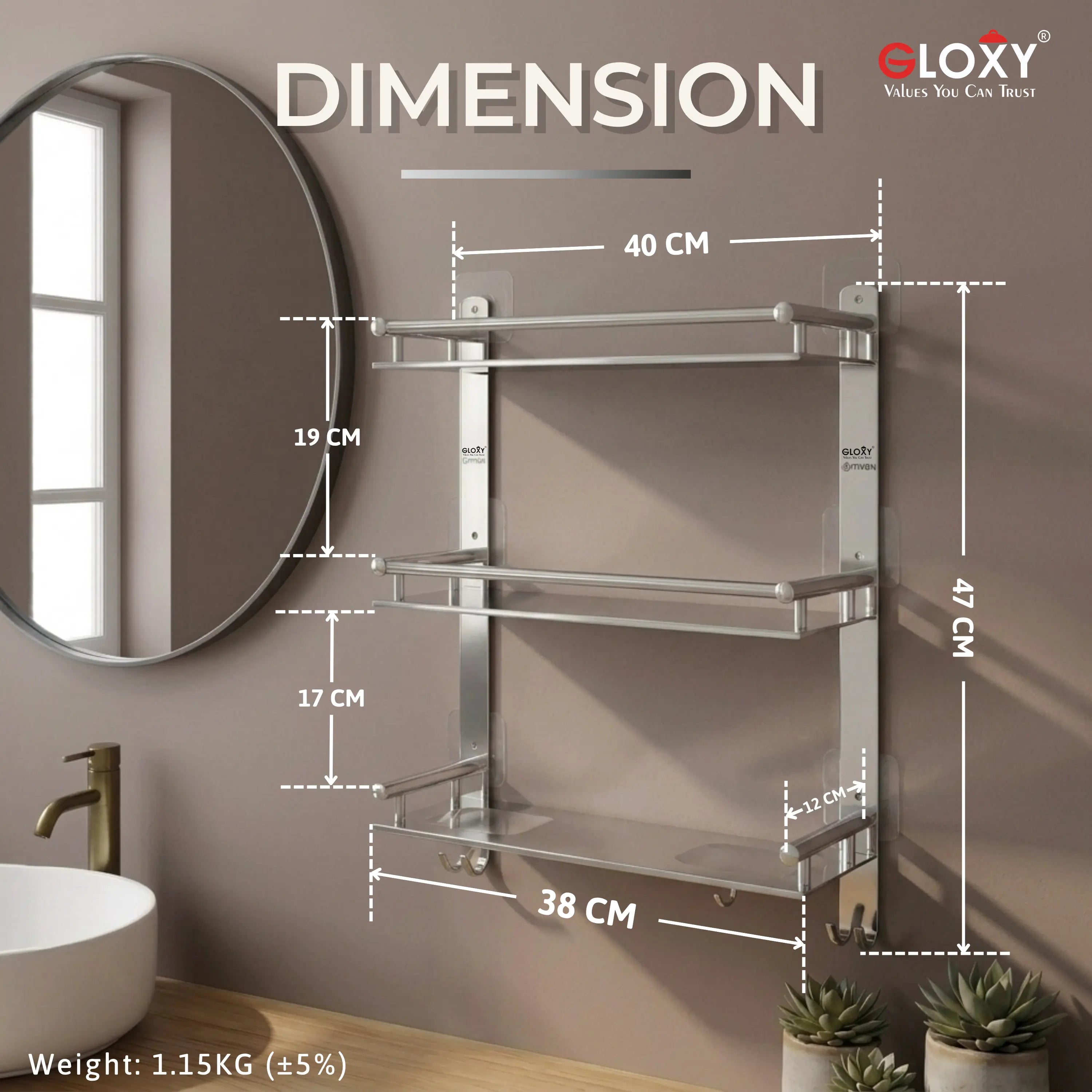 A wall-mounted three-tier bathroom towel rack with dimension annotations showing 40 cm shelf width, 19 cm and 17 cm vertical spacing, 47 cm total height, 38 cm base width, and weight 1.15KG, shown against a bathroom wall with a mirror, sink, and plants.