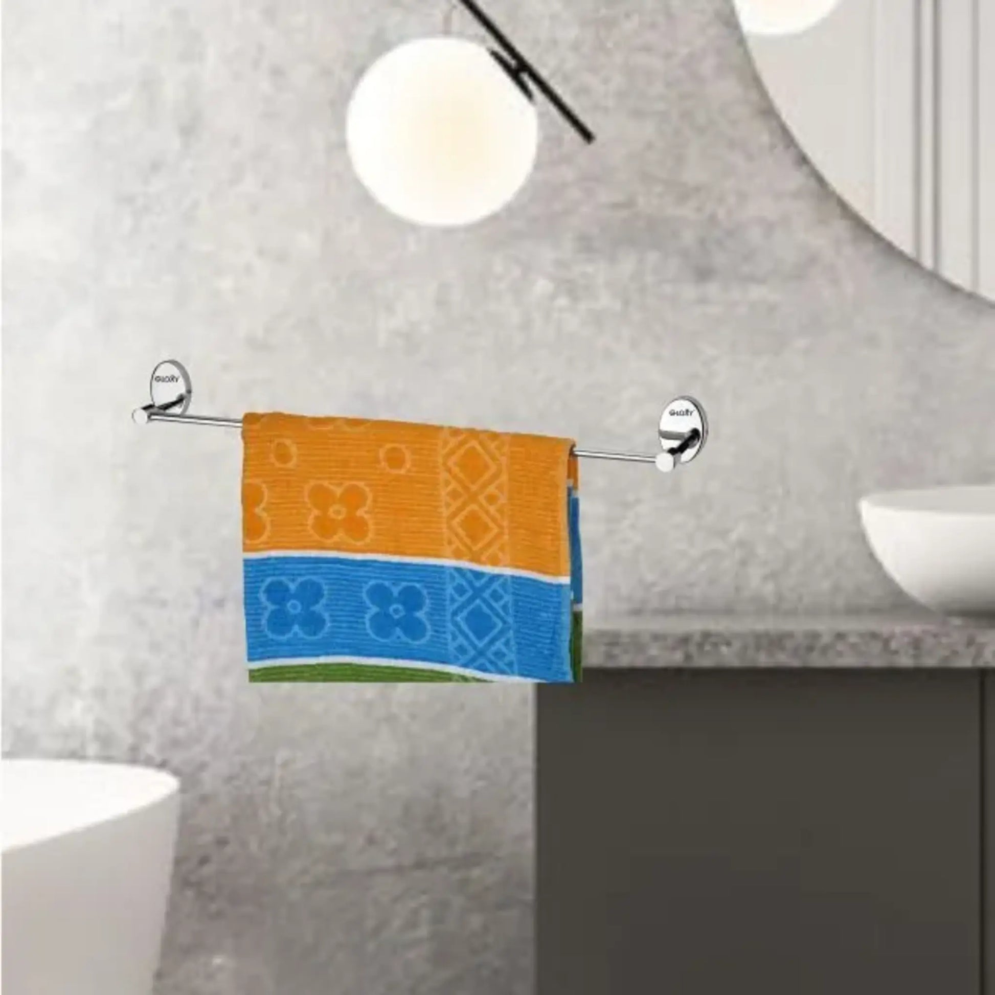 a metallic towel rack with a colorful towel hanging on against a textured wall.