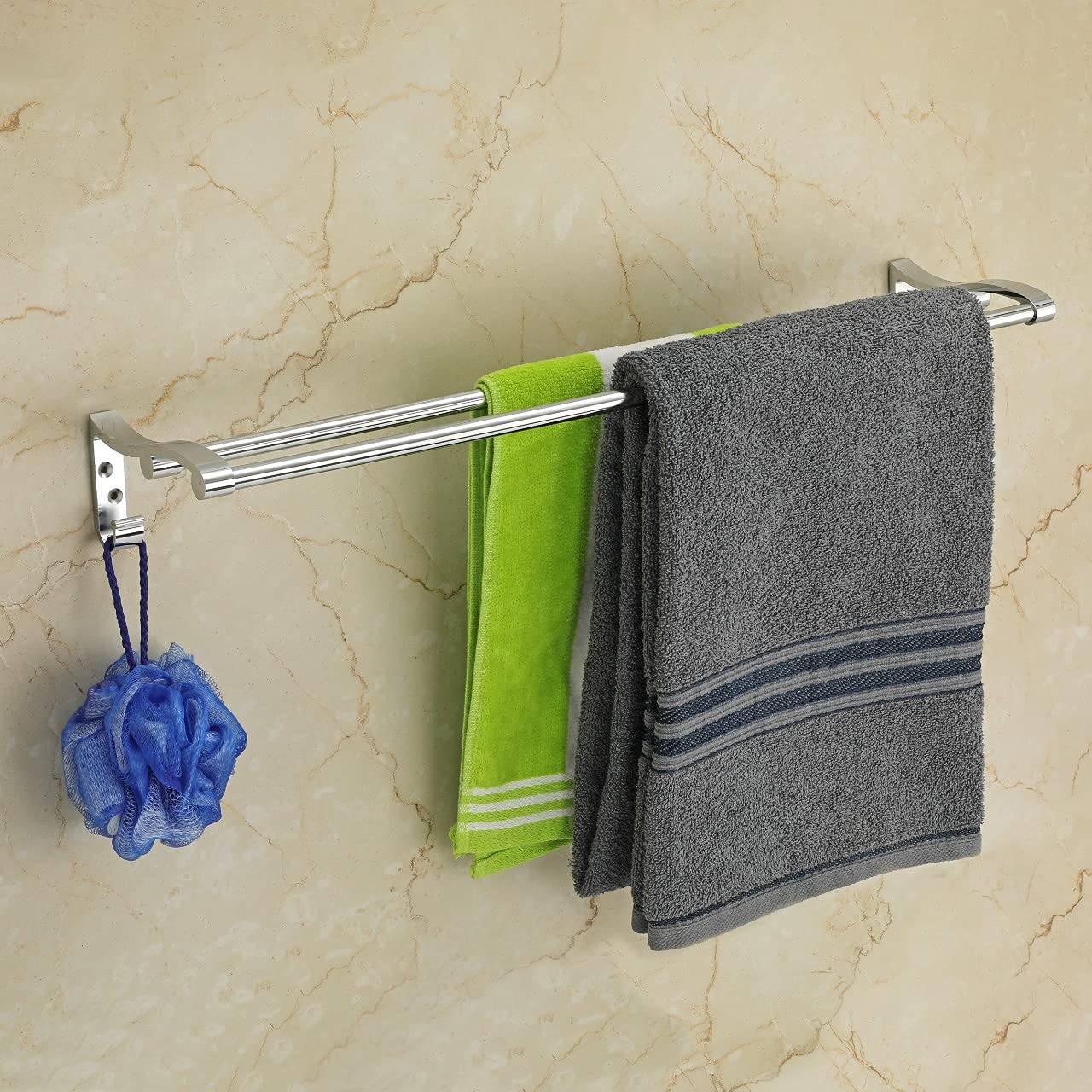 Towel rack with green and gray towels and a blue loofah on a marble wall.